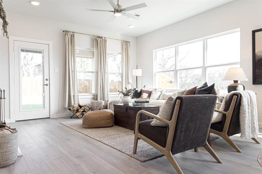 Living room with light wood-type flooring, a ceiling fan, and recessed lighting Living room with light wood-type flooring, a ceiling fan, and recessed lighting