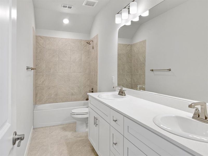 Guests will enjoy their own vanity space in this thoughtfully designed guest bath.