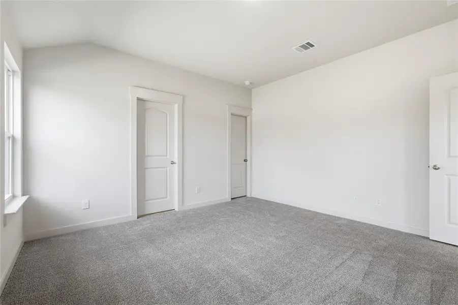 Unfurnished bedroom featuring carpet and lofted ceiling Unfurnished bedroom featuring carpet and lofted ceiling