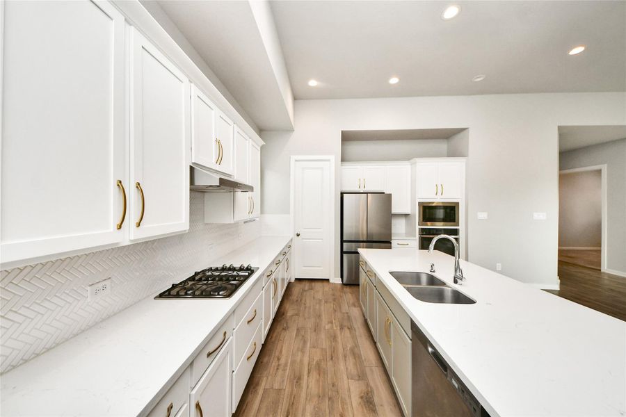 Modern kitchen with Quartz countertops, white cabinetry, and ample prep space