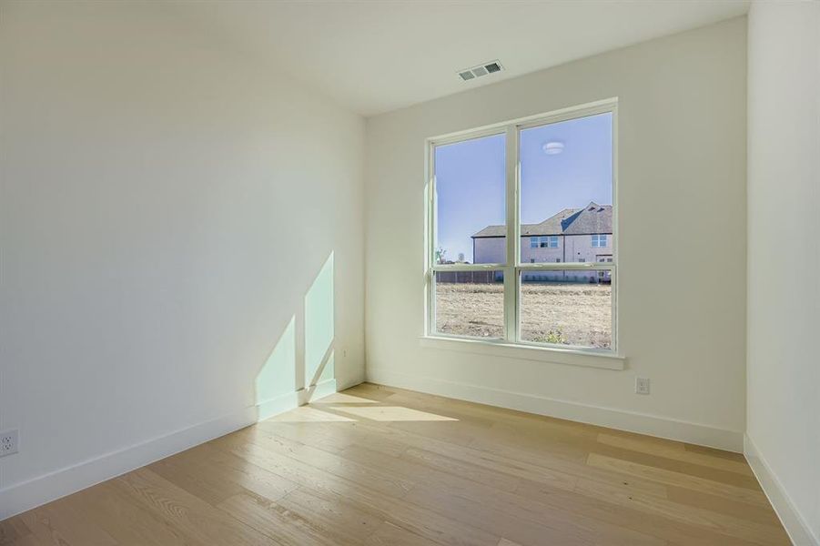 Spare room with light wood-style flooring and baseboards Spare room with light wood-style flooring and baseboards