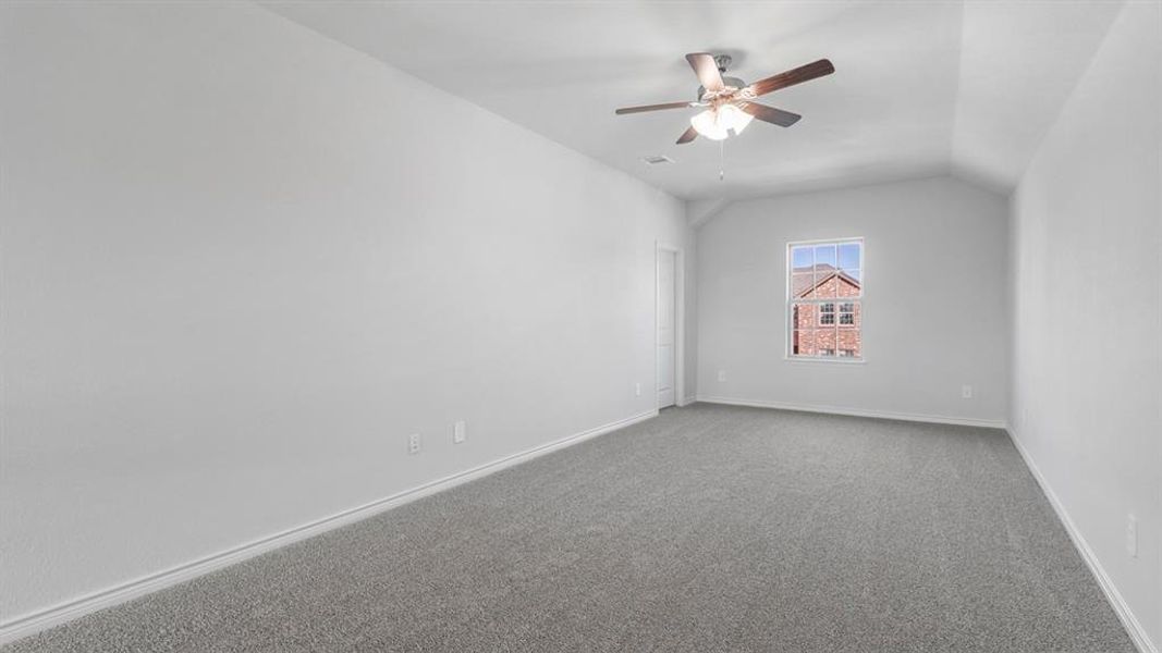 Additional living space featuring carpet flooring, lofted ceiling, and a ceiling fan