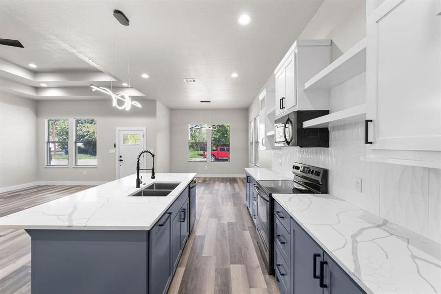 Kitchen with stainless steel appliances, a healthy amount of sunlight, sink, and white cabinetry