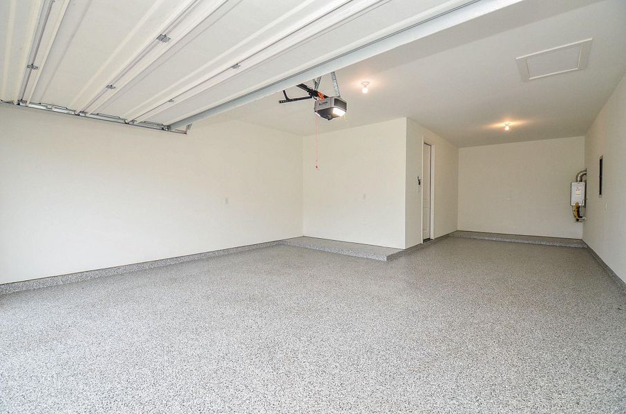 Tandem three-car attached garage with epoxy-finish flooring, garage-door opener, and side-door access to the home. Tankless water heater too!
