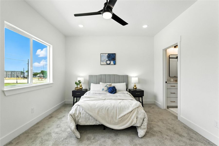 Primary bedroom has cozy carpet, a ceiling fan, and large windows that bring in so much light. Primary bedroom has cozy carpet, a ceiling fan, and large windows that bring in so much light.