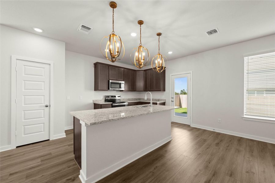 A well-lit kitchen with rich cabinetry and an inviting island, perfect for culinary adventures.