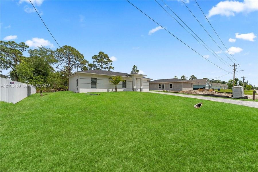 Manicured lawn, white privacy fence, and concrete driveway Manicured lawn, white privacy fence, and concrete driveway