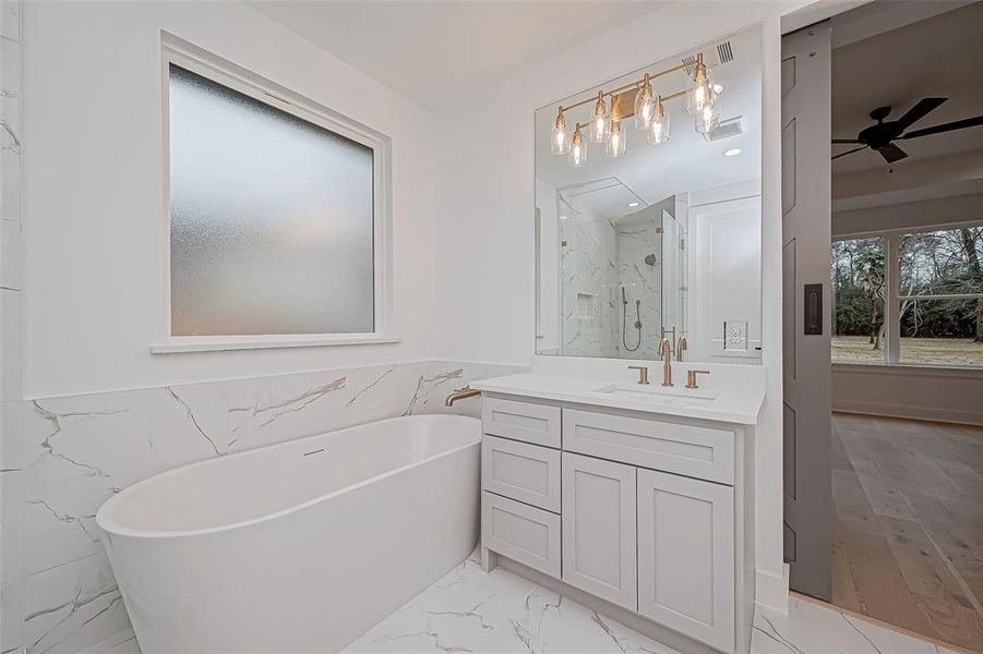 It includes a large mirrors with stylish lighting and a frosted window for privacy.