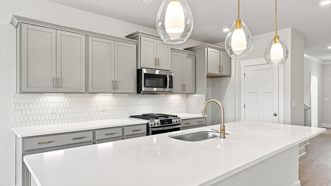 Exclusive DRB Homes kitchen with a 10-foot island, elevated finishes, and pendant lighting in a prime location Exclusive DRB Homes kitchen with a 10-foot island, elevated finishes, and pendant lighting in a prime location