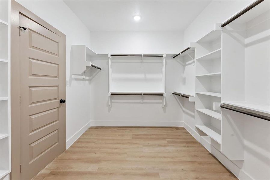 Spacious closet with light wood-type flooring Spacious closet with light wood-type flooring