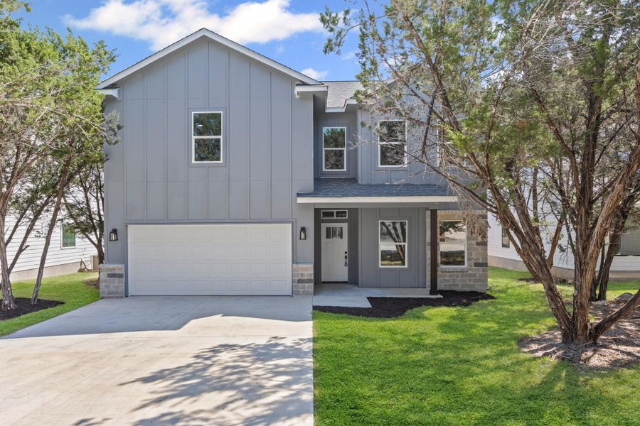 Modern farmhouse with board and batten siding, driveway, a porch, an attached garage, and a shingled roof Modern farmhouse with board and batten siding, driveway, a porch, an attached garage, and a shingled roof