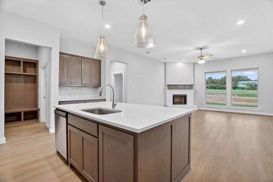 Kitchen island with light-toned cabinetry, a stainless steel sink, and white countertop