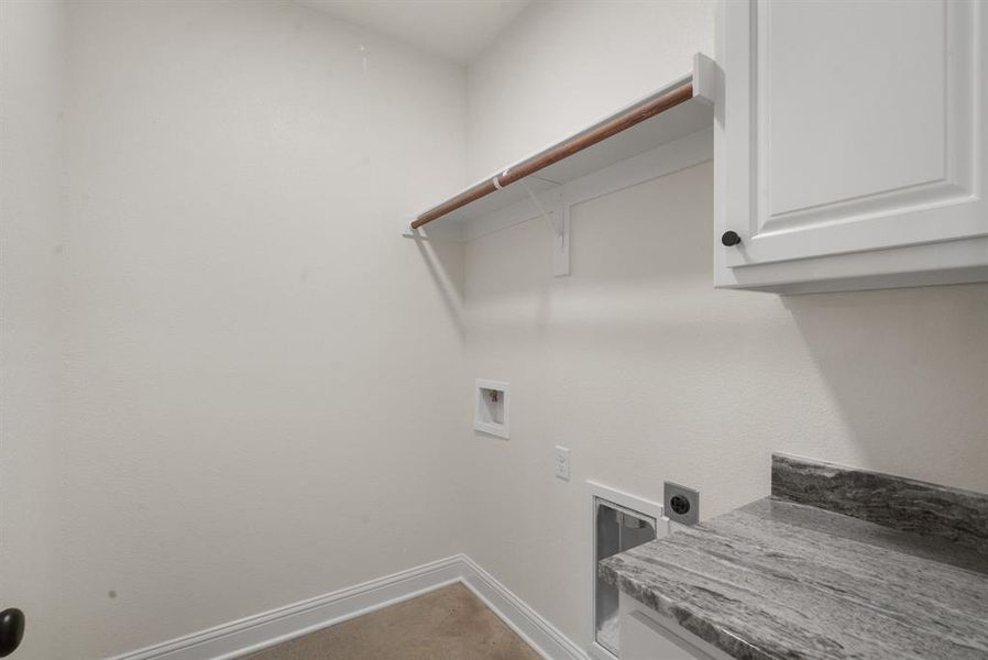 Clothes washing area featuring carpet floors, electric dryer hookup, cabinets, and washer hookup