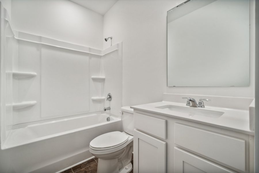 A bathroom with a tub sink and toilet.