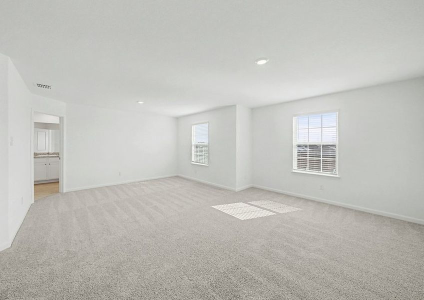 Expansive master bedroom with windows that create a bright, open space.