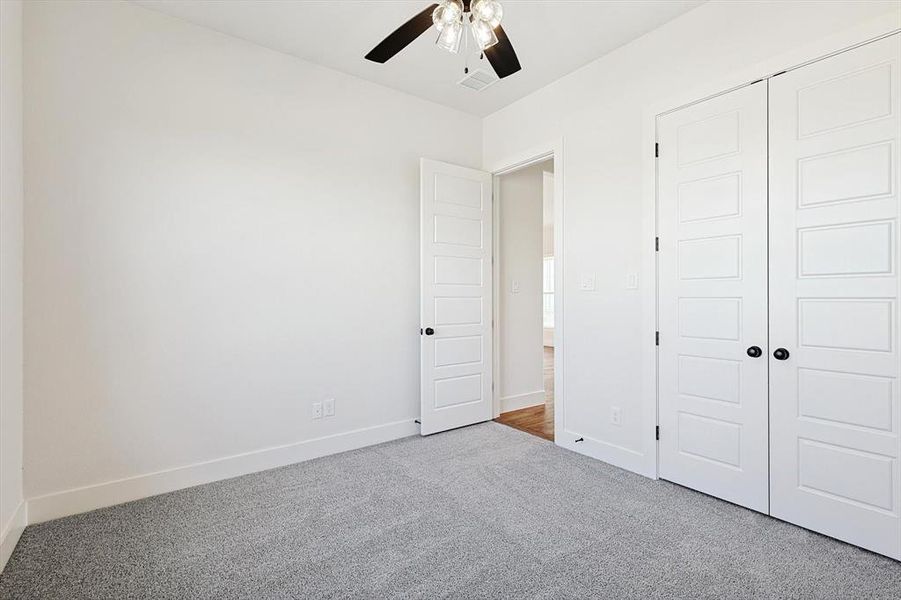 Unfurnished bedroom featuring carpet floors, a closet, and ceiling fan