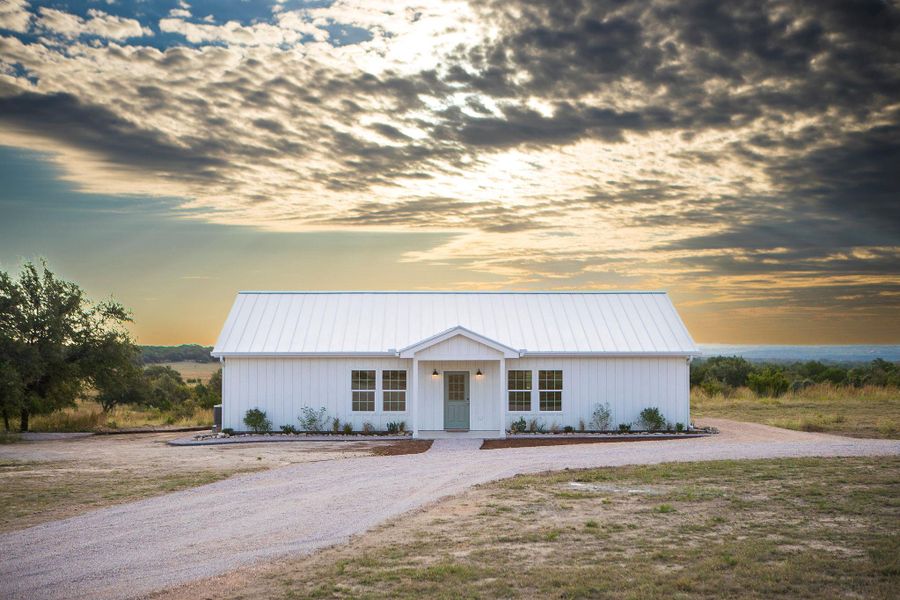 View of front of home with driveway, a metal roof, and board and batten siding View of front of home with driveway, a metal roof, and board and batten siding