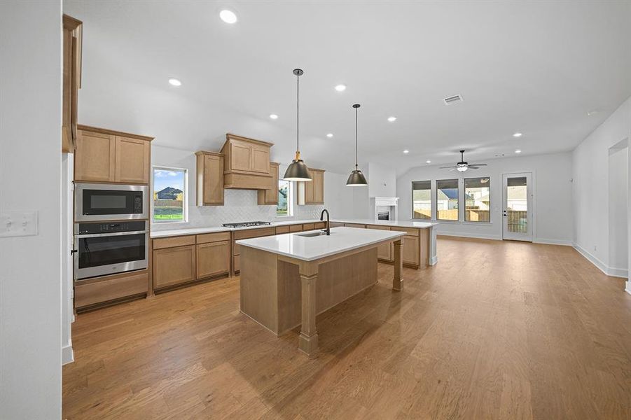Kitchen featuring a breakfast bar area, stainless steel appliances, open floor plan, recessed lighting, and a ceiling fan Kitchen featuring a breakfast bar area, stainless steel appliances, open floor plan, recessed lighting, and a ceiling fan