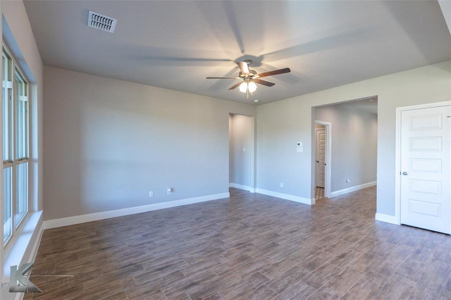 Unfurnished room with ceiling fan and dark wood-style floors