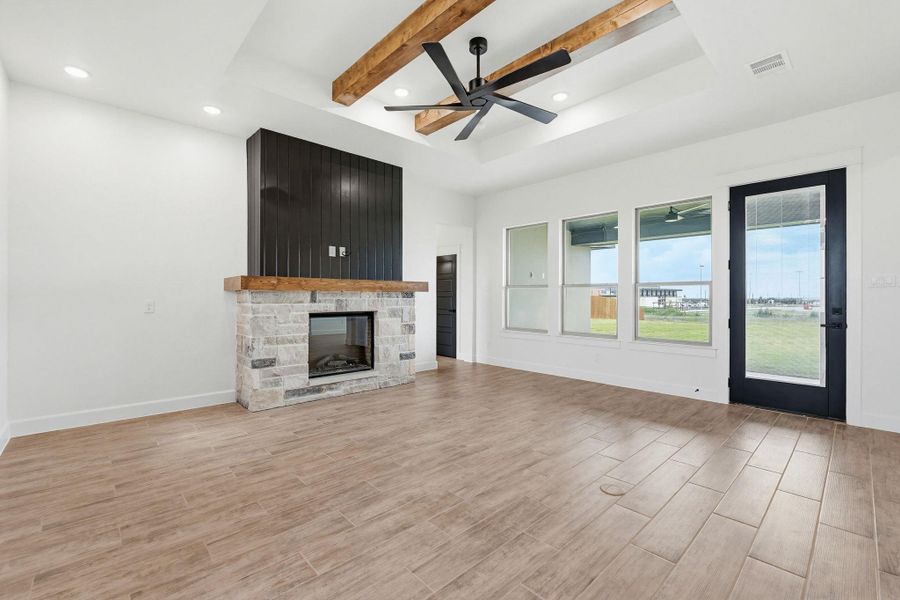 Discover a bright living area featuring a cozy fireplace and modern wood beam ceilings. Discover a bright living area featuring a cozy fireplace and modern wood beam ceilings.
