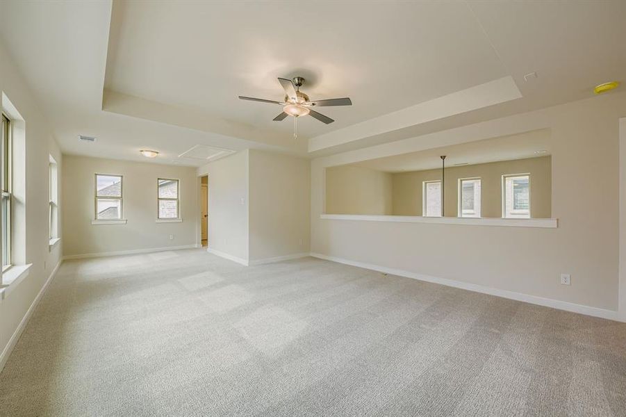 Game room featuring a raised ceiling, light colored carpet, and ceiling fan Game room featuring a raised ceiling, light colored carpet, and ceiling fan