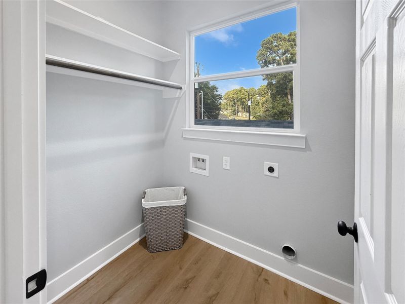 Spacious laundry room with built-in shelving for easy organizationand a large window providing a view of the outdoors, making chores feel less like a task. Includes Brand New Washer and Dryer