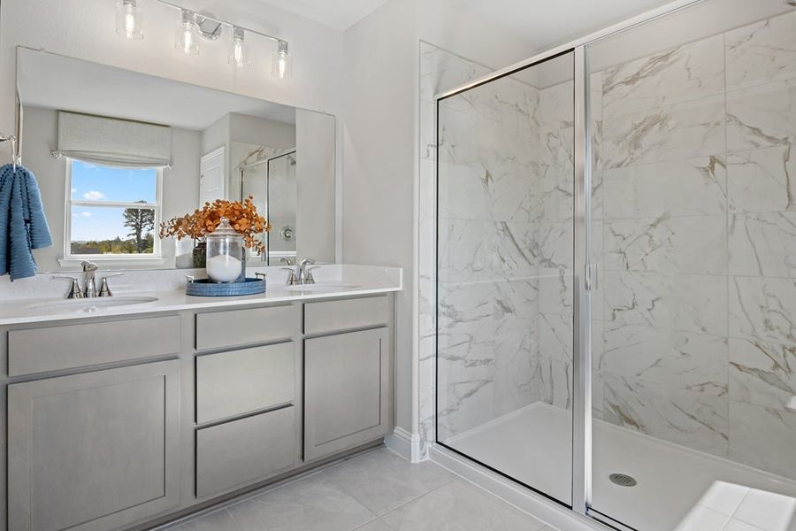 Walk-in shower with decorative tile surround at primary bath Walk-in shower with decorative tile surround at primary bath