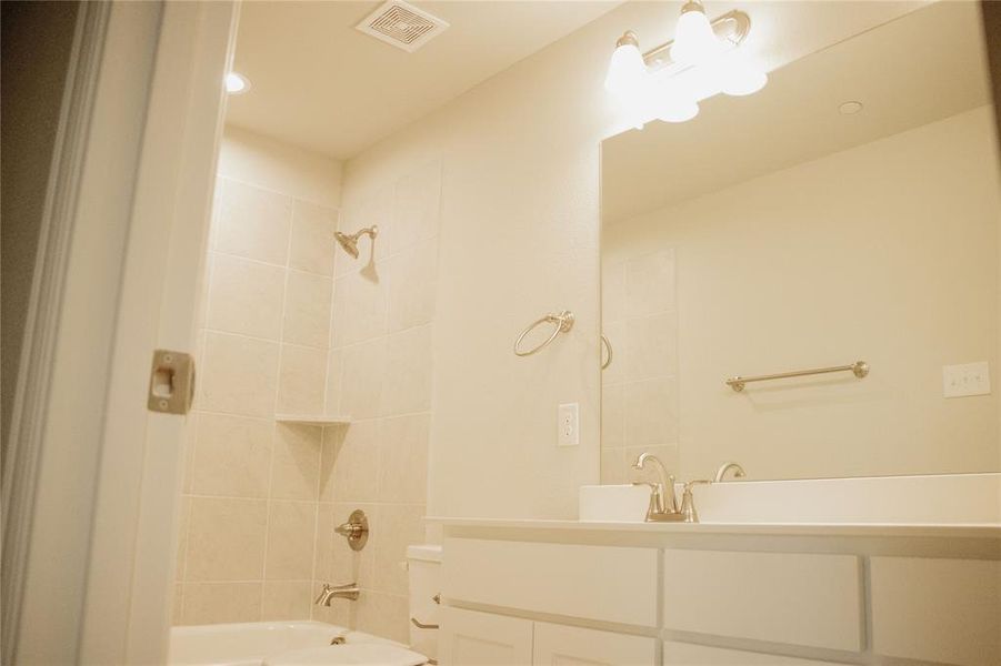 Bathroom with vanity and tiled shower / bath