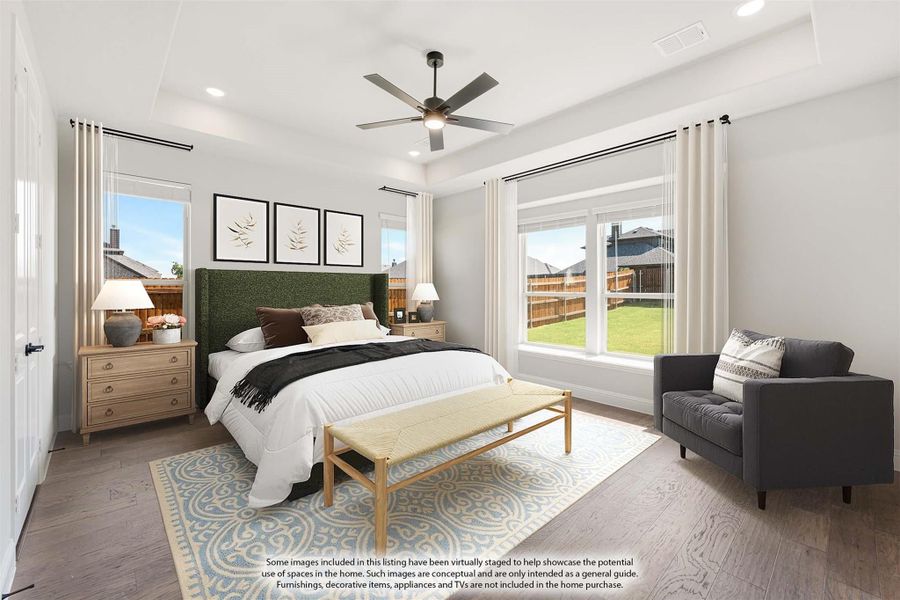 Bedroom with green upholstered headboard, ceiling fan, hardwood floors, and large windows with backyard view