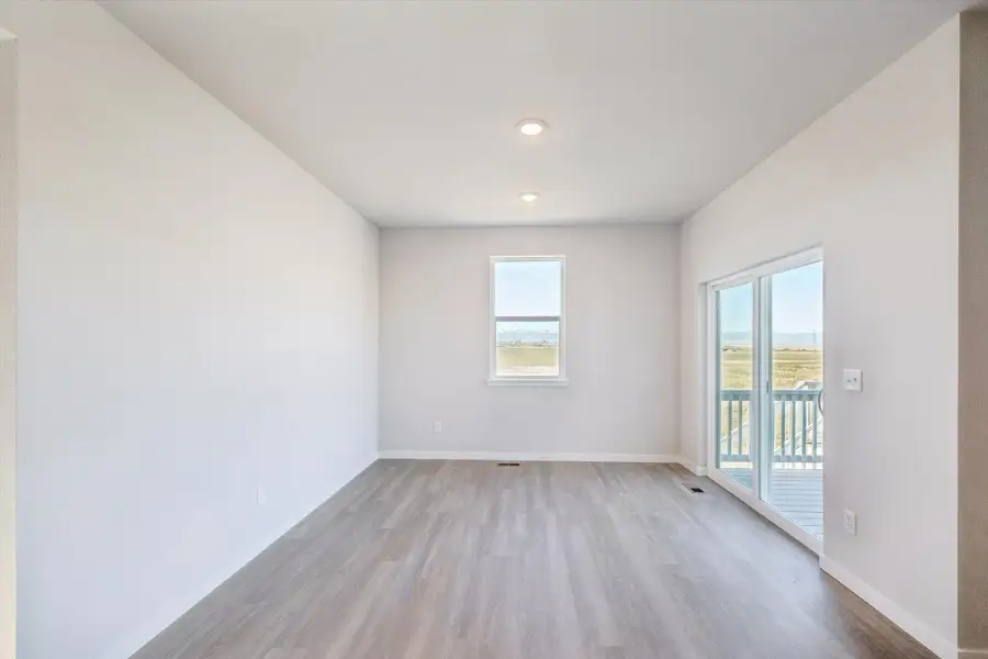 A room with a wood floor and a wood floor with a window.