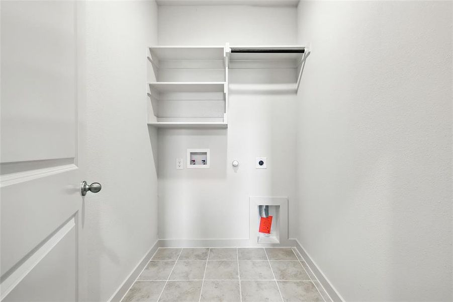 Laundry area featuring light tile patterned flooring, hookup for a gas dryer, hookup for an electric dryer, and washer hookup Laundry area featuring light tile patterned flooring, hookup for a gas dryer, hookup for an electric dryer, and washer hookup
