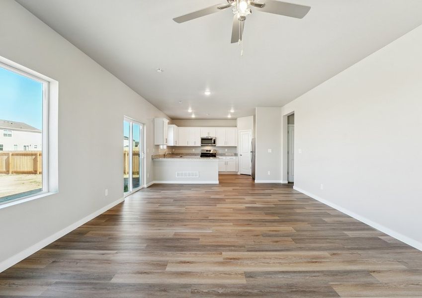 The family room is spacious with a ceiling fan and plank flooring.