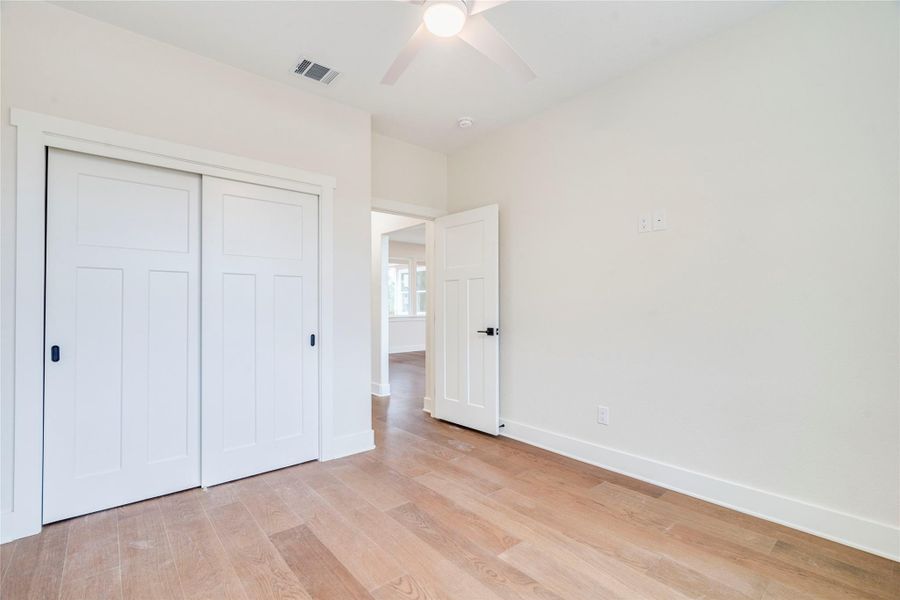Unfurnished bedroom with light wood-style flooring, a closet, and ceiling fan