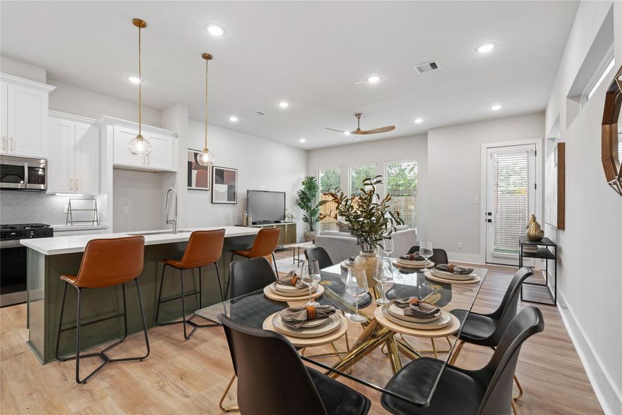 A seamless main level where defined spaces still feel connected. The designated dining area flows effortlessly into the kitchen and living room, all framed by large windows and elevated ceiling heights that keep the space open and bright. Welcome to Pech Landing!