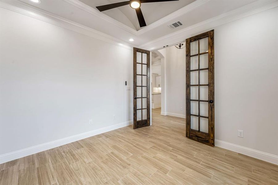 Spare room with ceiling fan, ornamental molding, light hardwood / wood-style flooring, and french doors