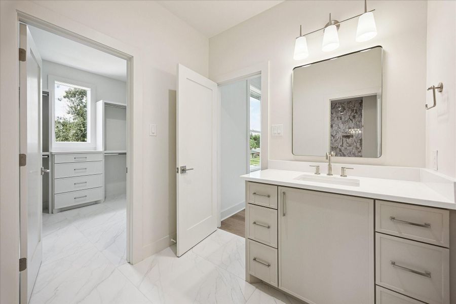 Comfort for everyone comes easy with this Hollywood style bathroom shared between two guest suites, each with a custom walk-in closet and private vanity, plus ample storage and a polished layout that keeps daily routines running smoothly.