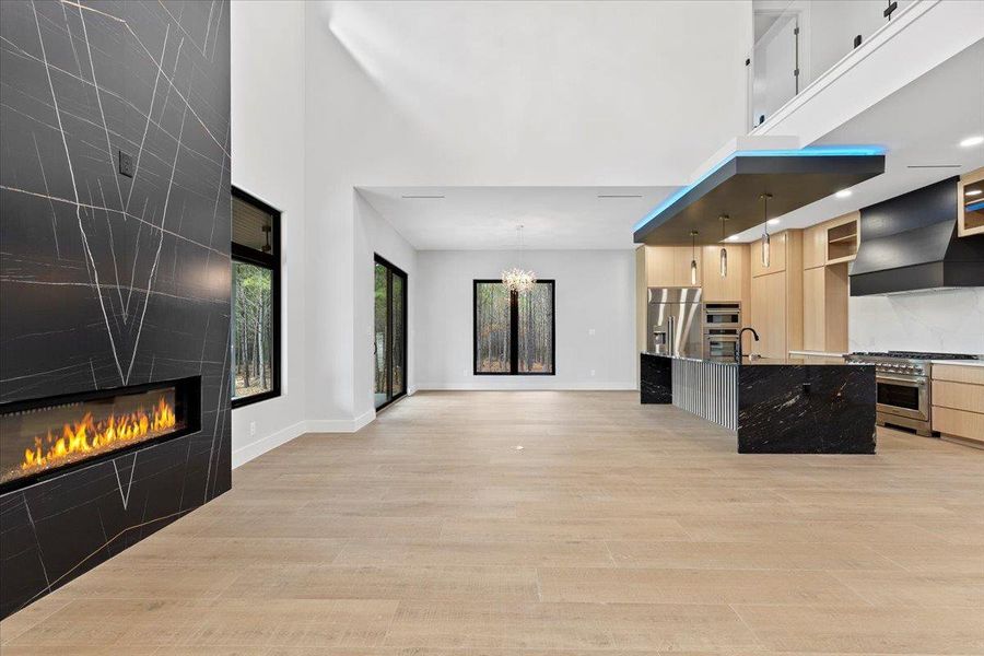 Living room with a gas fireplace, and a high ceilings Living room with a gas fireplace, and a high ceilings