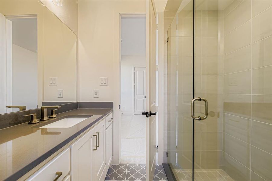 Bathroom featuring vanity, a shower stall, and light tile patterned flooring Bathroom featuring vanity, a shower stall, and light tile patterned flooring