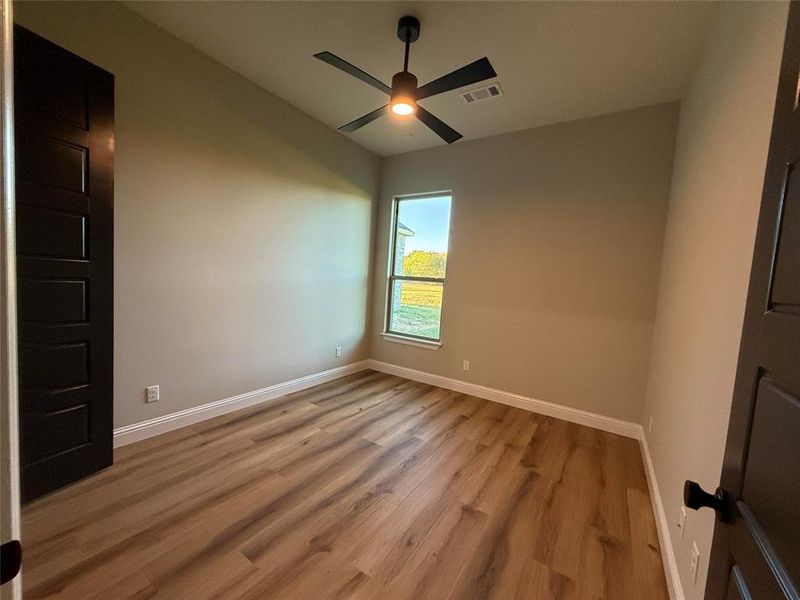 Spare room with light wood finished floors and a ceiling fan Spare room with light wood finished floors and a ceiling fan