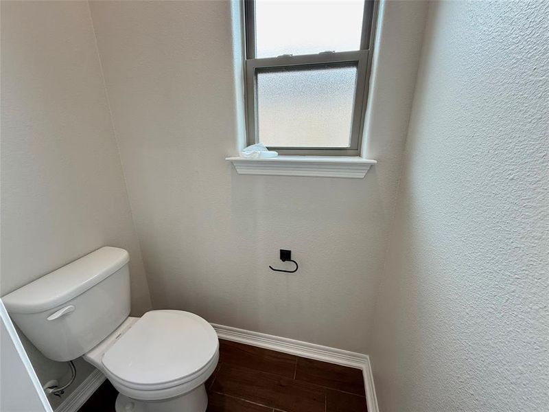 Bathroom featuring a textured wall and wood finished floors Bathroom featuring a textured wall and wood finished floors