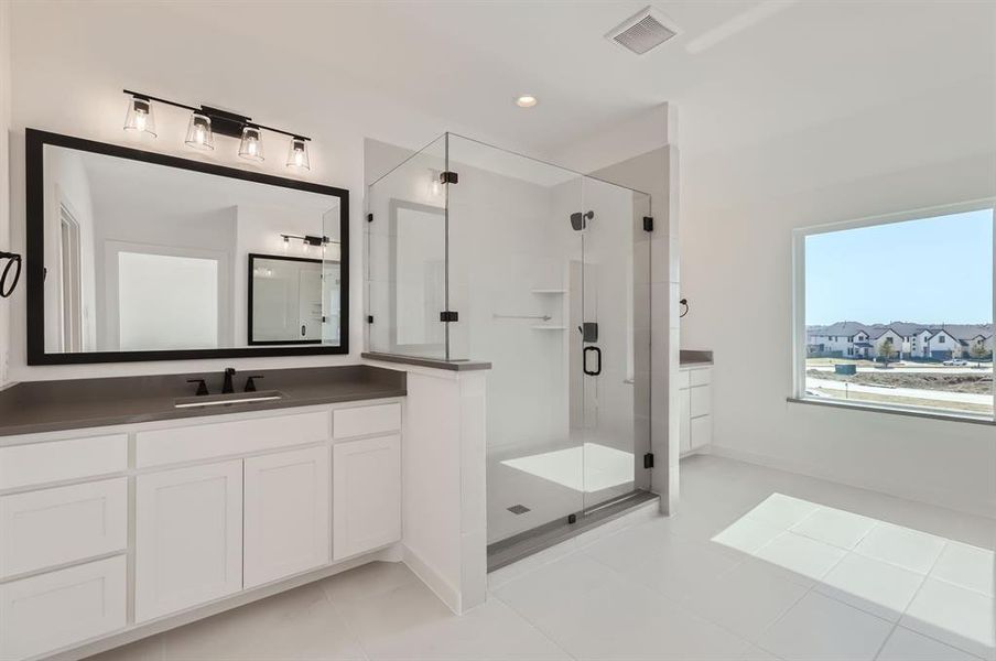 Bathroom with vanity, tile patterned floors, and an enclosed shower