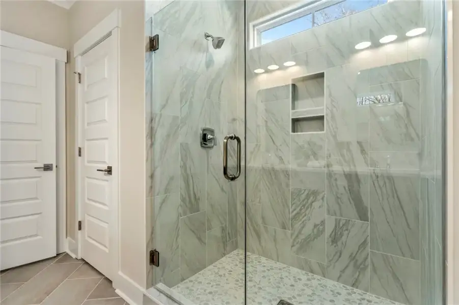 This sleek bathroom features a spacious shower wit
