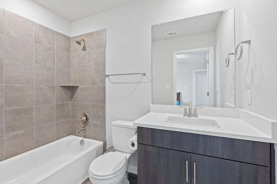 Bathroom featuring shower / bath combination, visible vents, toilet, and vanity Bathroom featuring shower / bath combination, visible vents, toilet, and vanity