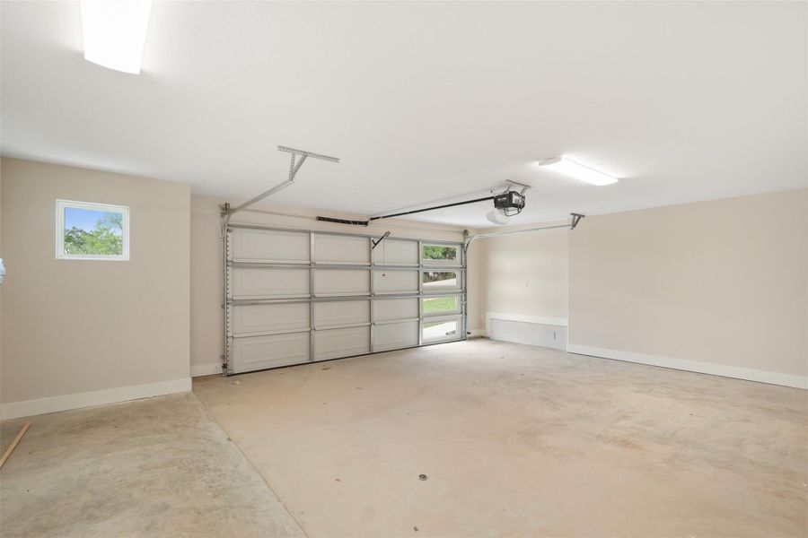 Garage featuring a garage door opener and baseboards Garage featuring a garage door opener and baseboards