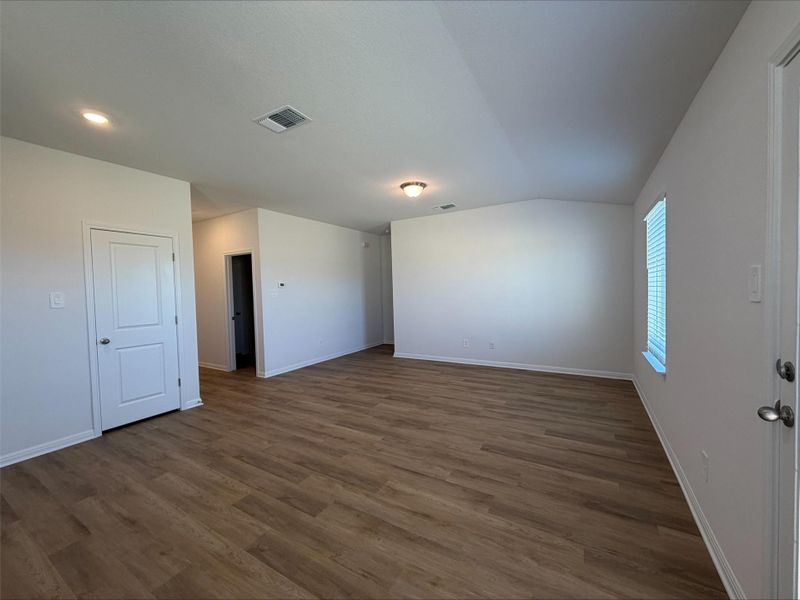 Unfurnished living room with dark wood-style flooring and lofted ceiling