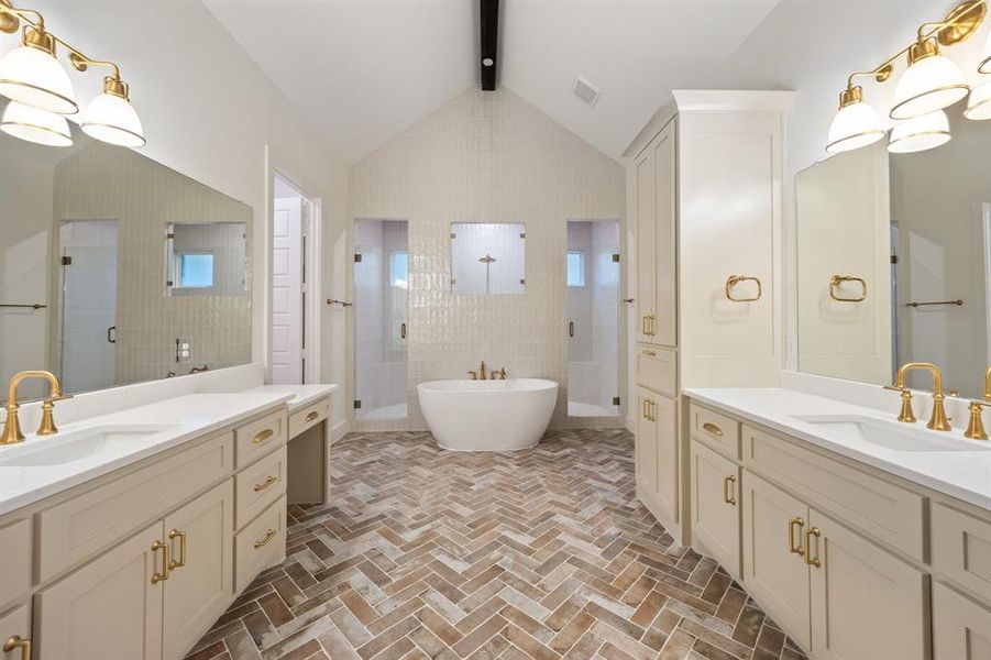 Bathroom featuring a stall shower, two vanities, brick flooring, and a soaking tub