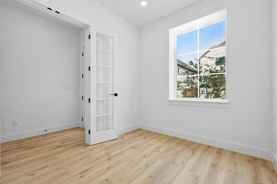 Spare room with healthy amount of natural light, baseboards, wood finished floors, and recessed lighting