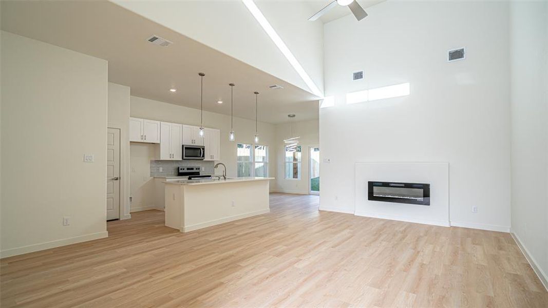 Spacious living area with vaulted ceilings and electric fireplace on a remote control