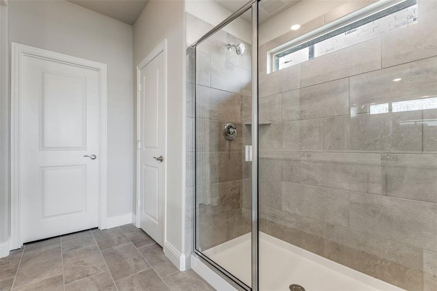 Primary  bath featuring an oversized shower and tile patterned floors