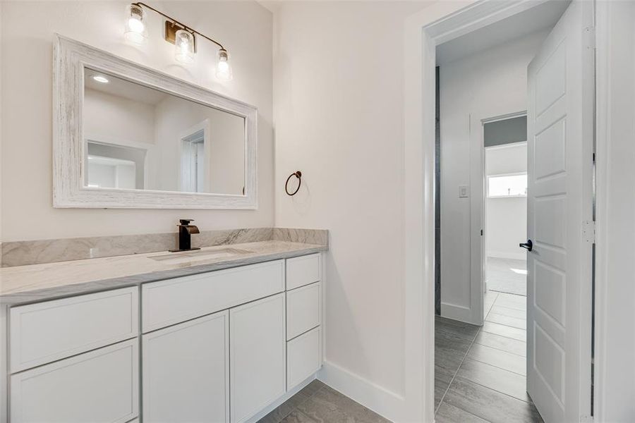 Bathroom featuring vanity and baseboards Bathroom featuring vanity and baseboards